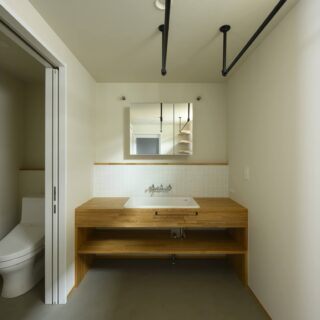 2階、洗面脱衣室、トイレ（左）。乾燥機などは使わず自然乾燥をご要望だったため、ハンガーパイプを多めに設置。ゆとりをもって洗濯物が乾かせるよう、洗面脱衣室そのものも広めに計画した。