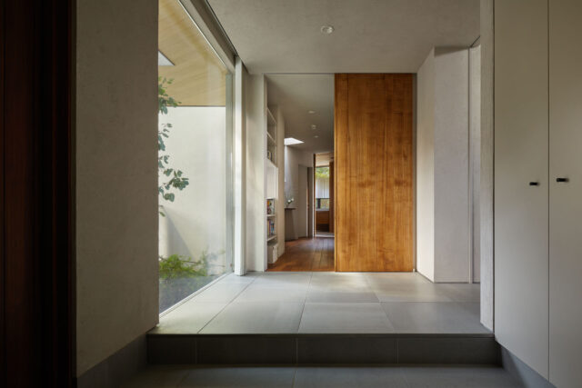 玄関。正面に進むと個室や水回り、右に入るとLDKがある。ところどころにハイサイドライトを設け、大きな家でも家中を明るくしている。画像奥に見えるハイサイドライトは、廊下だけでなくトイレに自然光を入れる役割も果たす