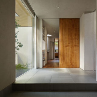 玄関。正面に進むと個室や水回り、右に入るとLDKがある。ところどころにハイサイドライトを設け、大きな家でも家中を明るくしている。画像奥に見えるハイサイドライトは、廊下だけでなくトイレに自然光を入れる役割も果たす