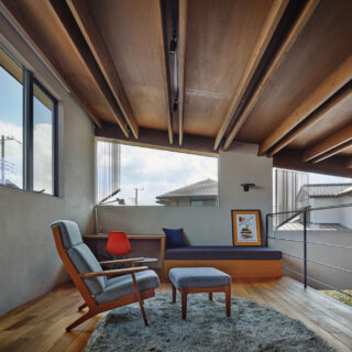 2階ロフト。木天井は強固に加工された建材を組み合わせ、梁成の細い、モダンな梁を実現した。２枚組み合わせた中にダクトレールを取り付け、天井の美しさは損なわずに明るさを確保。家の構成上斜めになった窓には縦型のブラインドを使い、日射や視線をコントロールする