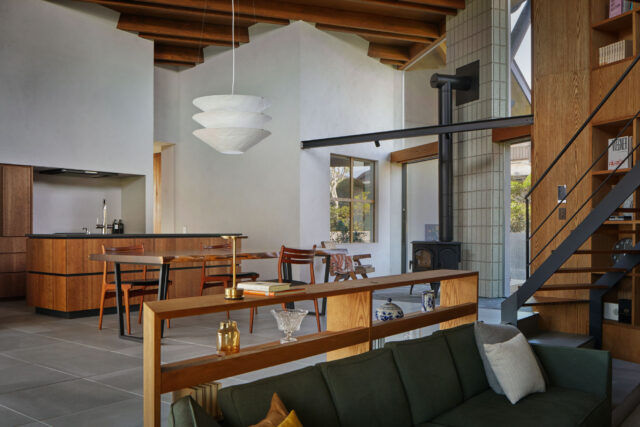 リビングからキッチン方向を見る。中央の窓の裏は子ども部屋。視線が交わることは少ないが様子はわかる、適度な距離感を実現。窓の前に設けられた暖炉テラスは、北側のデッキにと接しており外部の空気感も楽しみながら、落ち着いた時間を過ごせる