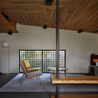 ラウンジからシアタールームを見る。格子窓の背後に電動の遮光ロールカーテンが設置され、ボタン一つで鑑賞の環境が整えられる。開口し、日光を豊かに入れたおかげで、様々な用途で活用できる居場所のひとつとなった