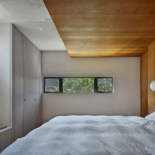 主寝室。以前の住まいの環境を反映し、量も仕舞い方もぴたりと合った収納を適切な場所に計画。窓を高い位置に配置し、日射を取り入れながら近隣からの視線を気にせず過ごせるようにした