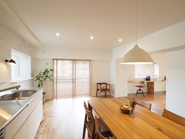 LDK側は窓のブラインドを上げると松並木の緑が見える好環境。リノベーションではオープンにできる引き戸やガラスの建具を多用して邸内の一体感を高めてあり、LDKを介した外の自然を玄関付近でも感じることができる。人と自然の関わり方を熟考するという佐藤さんらしい設計