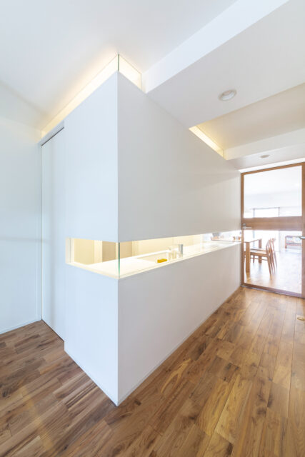 パウダールームの引き戸を閉めたところ。上下にガラスを入れた浮遊感のある壁が、光を柔らかく通す