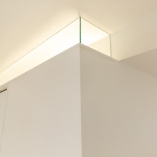 パウダールームの囲い壁は出ていた梁の高さに合わせ、天井付近にスリットを入れている。佐藤さんはこの先にもう1つ、ダミーで同じ梁状の出っ張りをつくり、2本の角材がパウダールームを貫通しているかのようにデザイン。不自然になりやすい梁を意匠に取り込む手腕はさすが