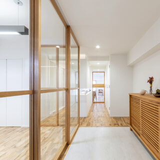 玄関からの眺め。仕事の来客対応を想定したアトリエ（写真左）のガラス戸を閉じると、ガラス戸の中桟、その奥にあるパウダールームの壁の水平スリット、奥のガラス扉の中桟が一直線になるように設計してある。奥行きを感じられ、本能的に美しいと思える空間