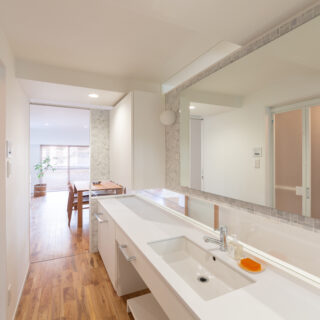 LDKと玄関の間に位置するパウダールームは両サイドを引き戸にし、正面の壁は水平スリットを入れ、宙に浮いているような軽やかなデザインで新調。引き戸を全開するとLDKの窓が見え、外の爽やかな自然を感じられる。光も風もスムーズに通り、邸内全体がぐっと明るくなった