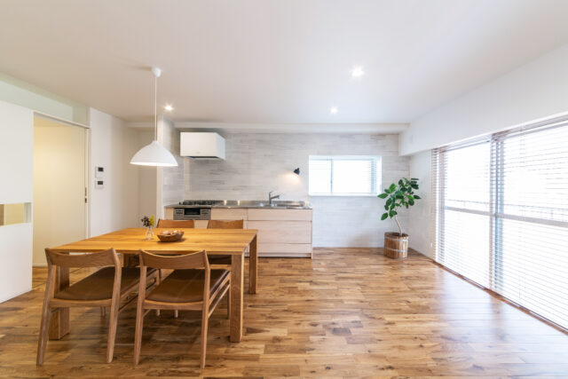 床はナラの無垢材をセレクト。真っ白な空間に有機的な表情がプラスされ、ホッとくつろげるナチュラルな心地よさが生まれている。キッチン周辺の壁はパウダールームとカラートーンを合わせ、濃淡のあるグレーのタイルを採用。こちらも白い空間の上品なアクセントになっている