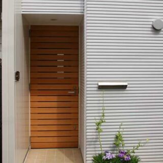 玄関ドアは造作。横スリットが入っているため、室内側も明るい。郵便ポストは室内で取り出せる位置に配置