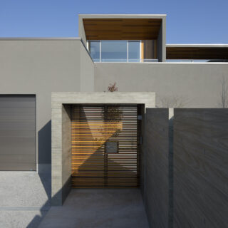 木格子の門扉を抜け、玄関へと続くアプローチはあえて長く取られた。一歩進むごとに期待感が高まっていく。一方で、ガレージからパントリーへ直結する動線を確保するなど、日々の利便性も確保。