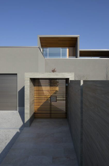 木格子の門扉を抜け、玄関へと続くアプローチはあえて長く取られた。一歩進むごとに期待感が高まっていく。一方で、ガレージからパントリーへ直結する動線を確保するなど、日々の利便性も確保。