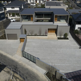 建物は、880㎡もの広大な敷地の北側に配置。将来の分割も視野に、空きスペースは舗装の来客用駐車場とした。排水性にも配慮したという。