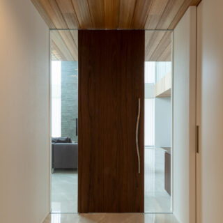 リビングドアの左右はガラス。玄関ホールからリビングが少しだけ見える。生活空間へ自然とつなげる意図だ