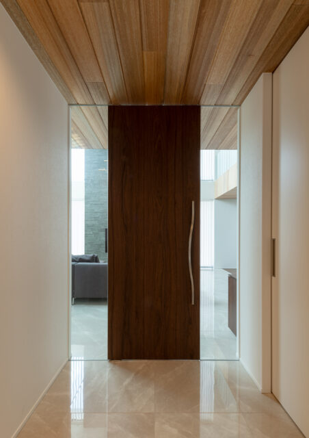 リビングドアの左右はガラス。玄関ホールからリビングが少しだけ見える。生活空間へ自然とつなげる意図だ