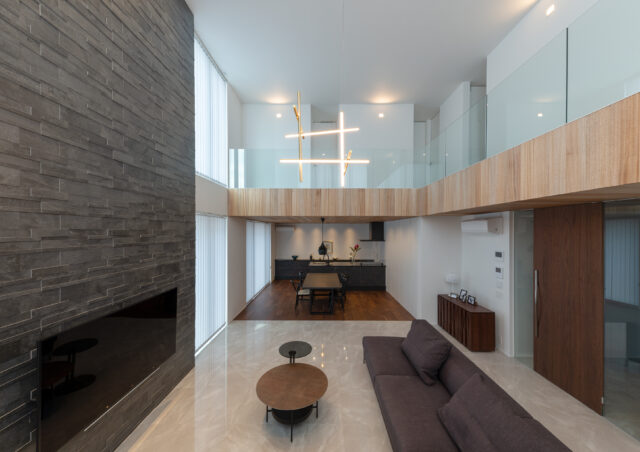 リビングの庭側（写真左側）に配置された、大きなタイル壁。強すぎる日当たりを、適度に調整できる。大理石調の床タイルは玄関から続き、空間の連続性を感じられる