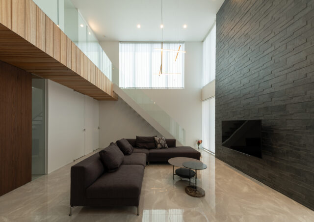 タイル壁を暗色とすることで、吹き抜け空間の高さをより強く感じられるように計算されている