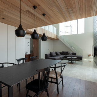 ダイニング。あえて天井高を下げ、落ち着いて食事ができる空間に。ダイニングの後ろ（写真左側）には一面の収納を配置。リビングではなくダイニングに収納があるのは、ダイニングで過ごす時間が長いというヒアリングからだ