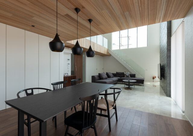 ダイニング。あえて天井高を下げ、落ち着いて食事ができる空間に。ダイニングの後ろ（写真左側）には一面の収納を配置。リビングではなくダイニングに収納があるのは、ダイニングで過ごす時間が長いというヒアリングからだ