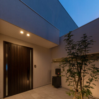 玄関前夕景。シンボルツリーの照明も同時に設計した。駐車場の天井照明や玄関の照明も美しい