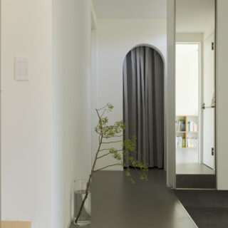 1階。ウォークインクローゼットは透け感のあるカーテンで仕切った。アーチとともに柔らかな印象を与える