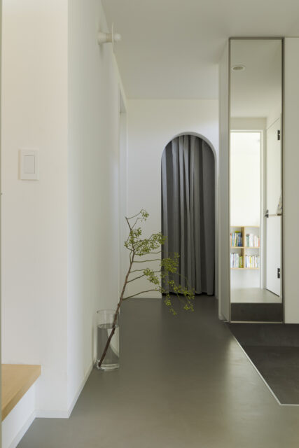 1階。ウォークインクローゼットは透け感のあるカーテンで仕切った。アーチとともに柔らかな印象を与える