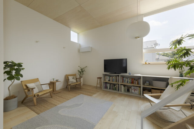 2階リビングはロフトまでの吹き抜けで天井が高く、開放的。シナ合板の天井に合わせ、グレーやグリーンをプラスし温もりに満ちたインテリアとした。明るいメープルのフローリングは幅が広めのものを採用し、空間のおおらかさを引き立てている