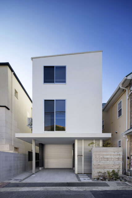 年月を重ねても目地が出ないよう、２・３階は下地にモルタル塗りを採用し、その上から塗装を施した外観。四方に回した廂下の空間を有効利用するため、複数ある室外機はすべて上階に設置している