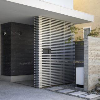 セメント素材に着色塗装をせず、素地そのものの風合いを生かす外壁材『SOLIDO』をガレージ部分に採用。経年変化で表面に生じる白華のムラも、自然の意匠ならではの味わいになる