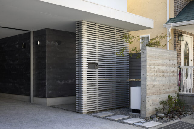 セメント素材に着色塗装をせず、素地そのものの風合いを生かす外壁材『SOLIDO』をガレージ部分に採用。経年変化で表面に生じる白華のムラも、自然の意匠ならではの味わいになる