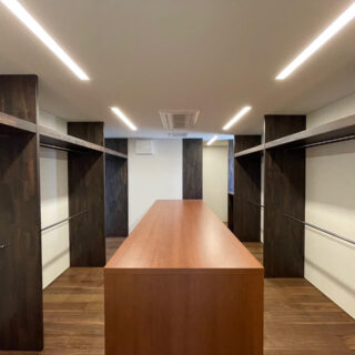 「他の住宅を見学した際のクローゼットが気に入られて同じような物がほしい」というリクエストに応じてつくられたWIC。中央の台は、収納であり作業台としても使える。スーツケースを広げ、荷物を詰めるのにも便利だ。