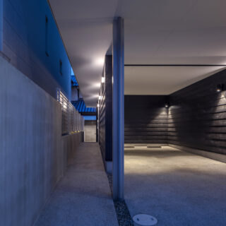 路地のような佇まいが印象的なアプローチ。ベビーカーでの移動に配慮した段差のないスロープ設計かつ四方に廂を回してあるため、雨でも濡れずに安心して移動ができる