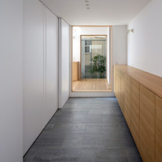 玄関から家の中に入るとまず、余白を意識したゆとりのある空間が迎えてくれる。抜け感を演出するため、突き当たりにFIX窓を設けて外の坪庭と自然光を取り込んだ