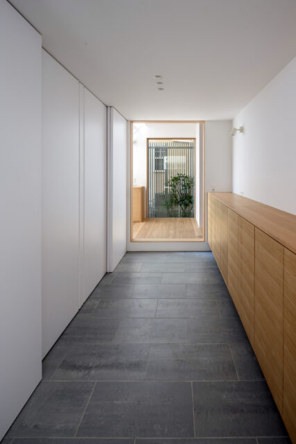 玄関から家の中に入るとまず、余白を意識したゆとりのある空間が迎えてくれる。抜け感を演出するため、突き当たりにFIX窓を設けて外の坪庭と自然光を取り込んだ
