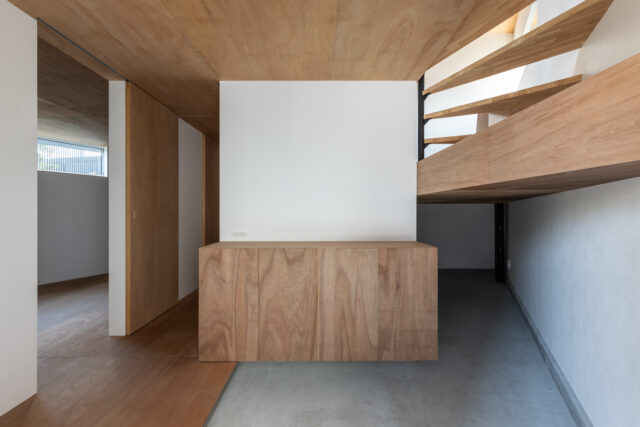 玄関左手には、主寝室。中央には家族の衣類を一括管理するファミリークローゼットを配置。右奥には、玄関土間からそのままアクセスできる天井高を抑えた納戸スペースがある。自転車やアウトドア用品を収める、都市生活における貴重な「蔵」のような役割。