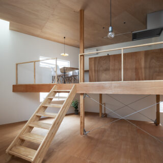 ラワン合板を用いた天井と床の木の温もりが、白い壁に優しく調和する。トップライトから差し込む光が、敷地面積19坪という数字を忘れさせる家族のリビングを明るく照らし出す。