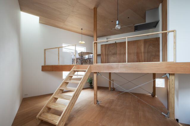 ラワン合板を用いた天井と床の木の温もりが、白い壁に優しく調和する。トップライトから差し込む光が、敷地面積19坪という数字を忘れさせる家族のリビングを明るく照らし出す。