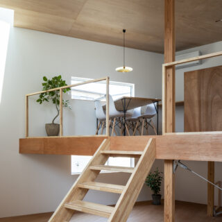 リビングの上には、宙に浮いたようなダイニングキッチン。階段はあえて真ん中に。この階段はベンチにもなり、リビングで寛ぐアイテムとしても活用されている。