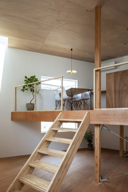 リビングの上には、宙に浮いたようなダイニングキッチン。階段はあえて真ん中に。この階段はベンチにもなり、リビングで寛ぐアイテムとしても活用されている。