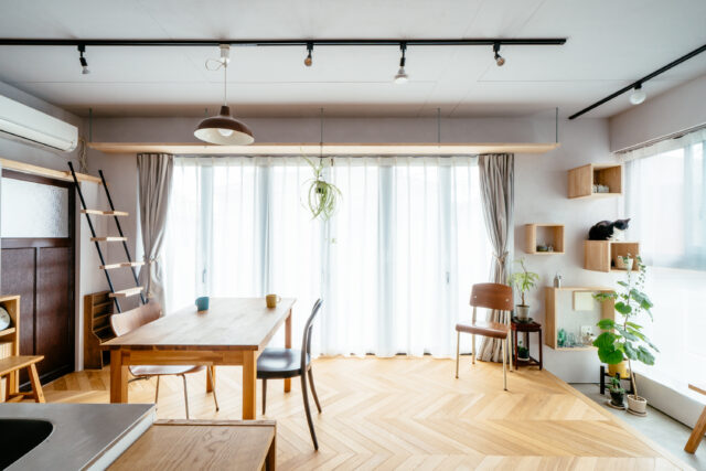 明るく光あふれるLDK。カーテンレールと高さを揃えたキャットウォークがあり、その両側にはしごと箱収納を設けて、二方向に出られるよう工夫されている。