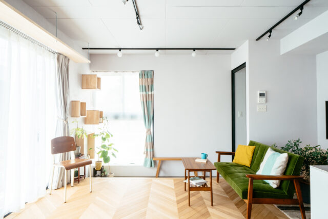 玄関の内側に猫の脱出防止のためのガラス戸を設けた。Kさんリクエストのフレンチヘリンボーンの床、Kさんたちで手塗りした薄いグレーの塗装で、どこか懐かしく温かみのある落ち着いた雰囲気に。