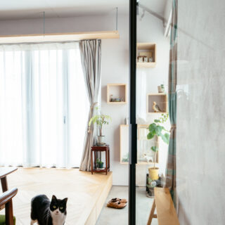 玄関から土間が一直線に伸びる。この土間は陽の光を浴びながら寛げるインナーテラスとしての表情をもつ。猫が出迎えてくれたフローリング下には、靴収納の引出しがある。