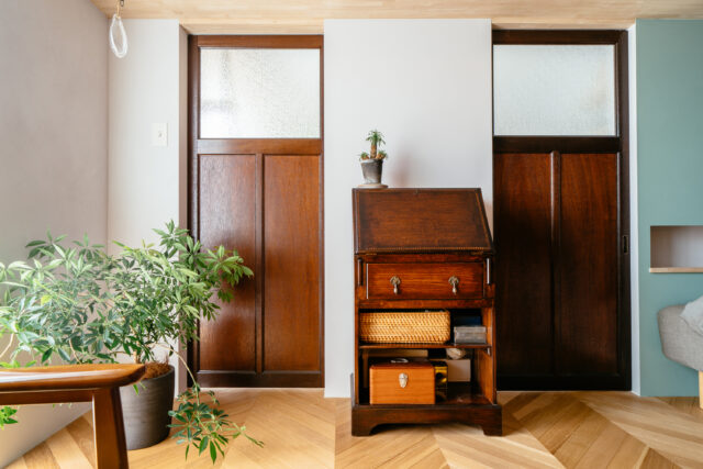 寝室との境には、念願だった古建具の扉を。将来二分割できるようにあえて2枚の扉とした。ベッド部分の壁は、ライトグリーンのアクセントを。