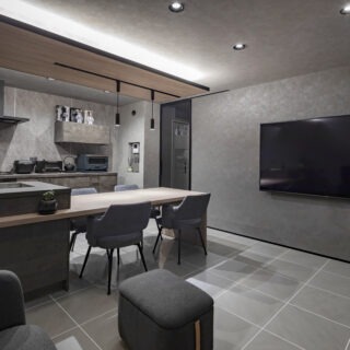 3階兄世帯LDK。テレビを設置した壁面は余計なものをつけず、シンプル空間を強調。配線やゲーム機などは画像のさらに右に折れ曲がるように設けた収納棚にまとめ、気配を隠した